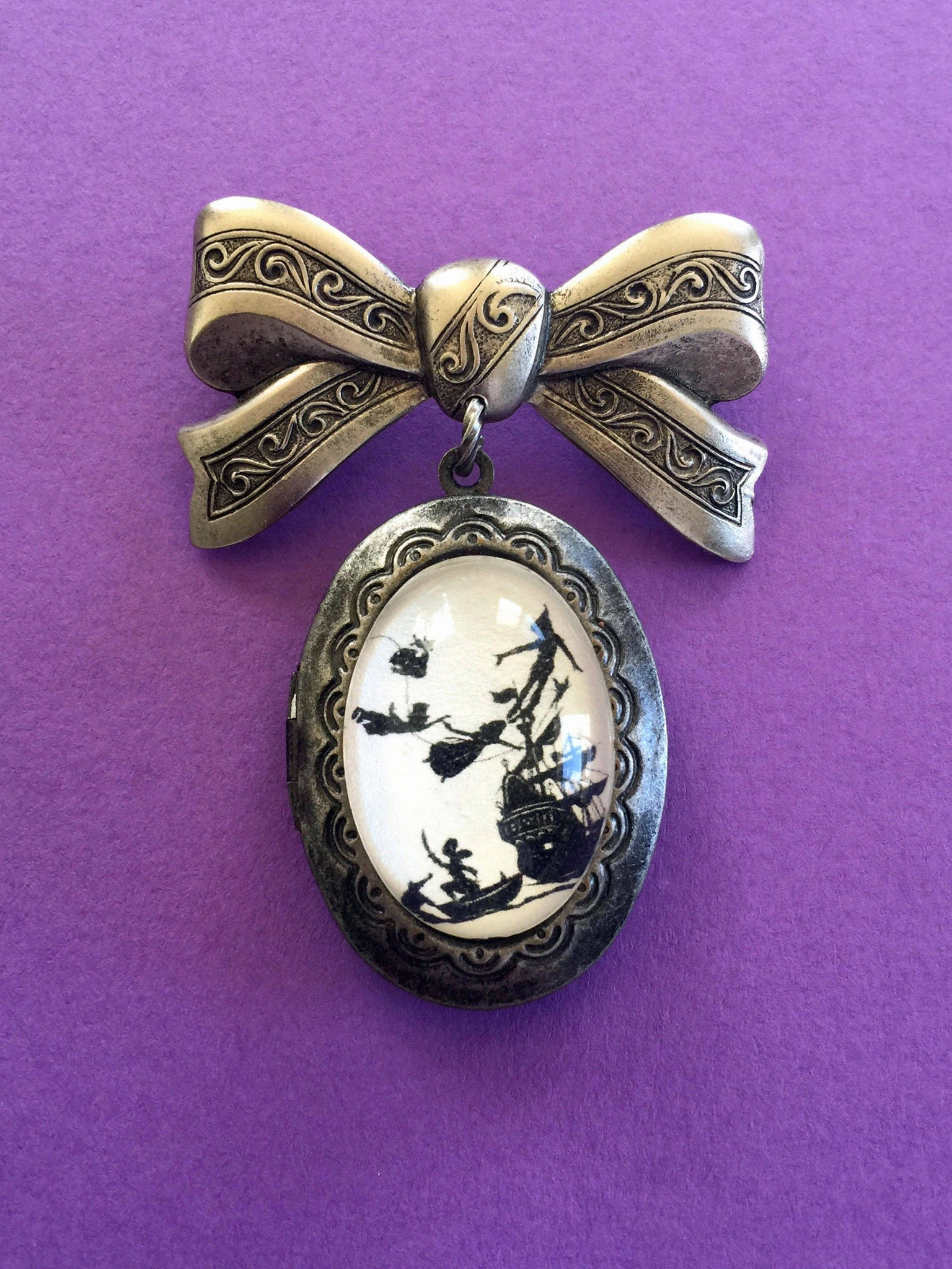 PETER PAN Brooch - locket pendant on bow pin - Silhouette Jewelry